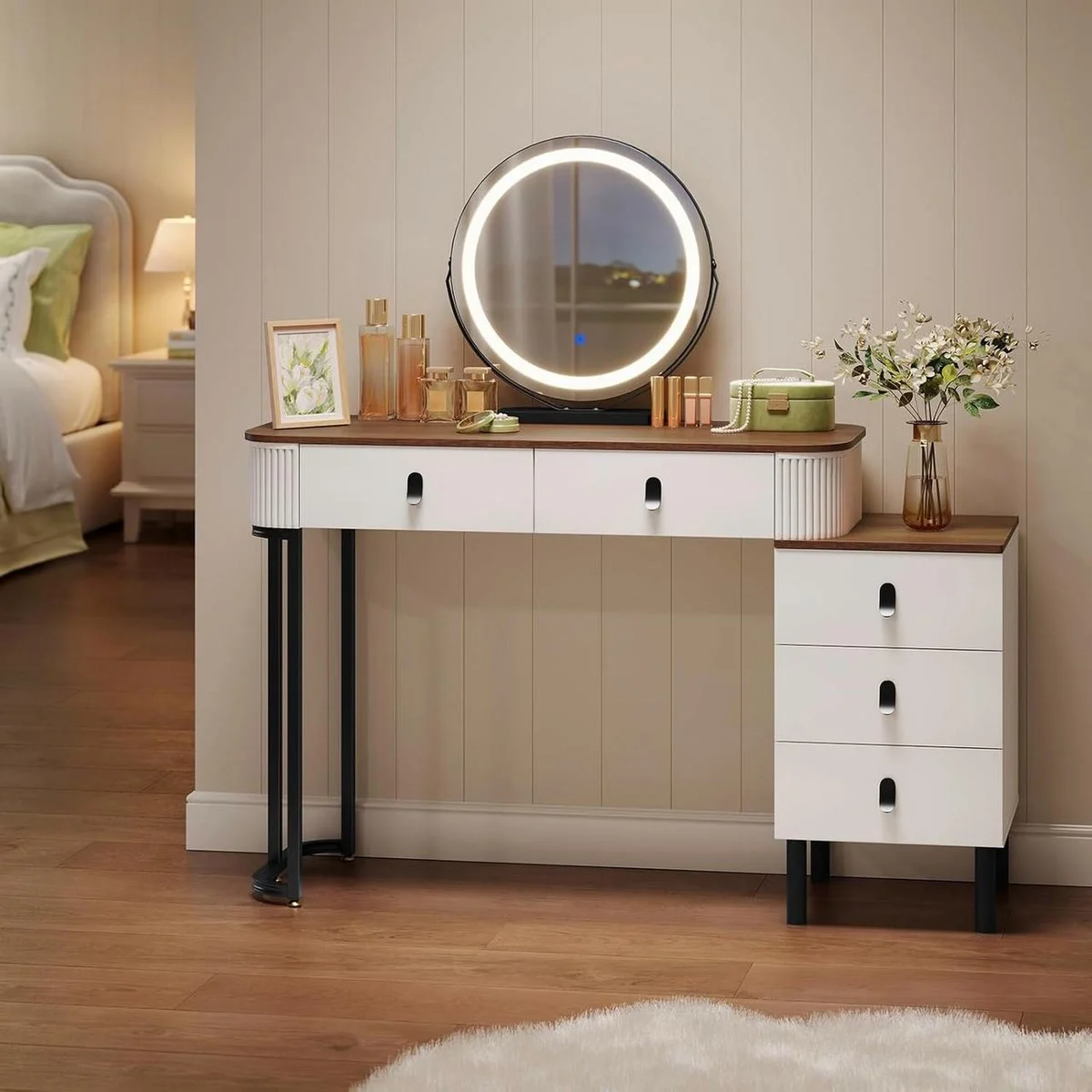 Tocador de maquillaje de madera y blanco de 100 cm en un dormitorio, con espejo redondo con luz y la cómoda a la derecha